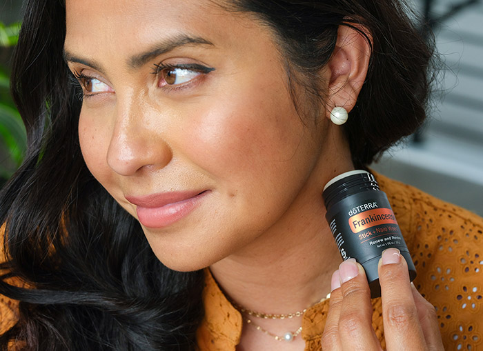 A women rubbing the Frankincense Stick on the side of her neck. 