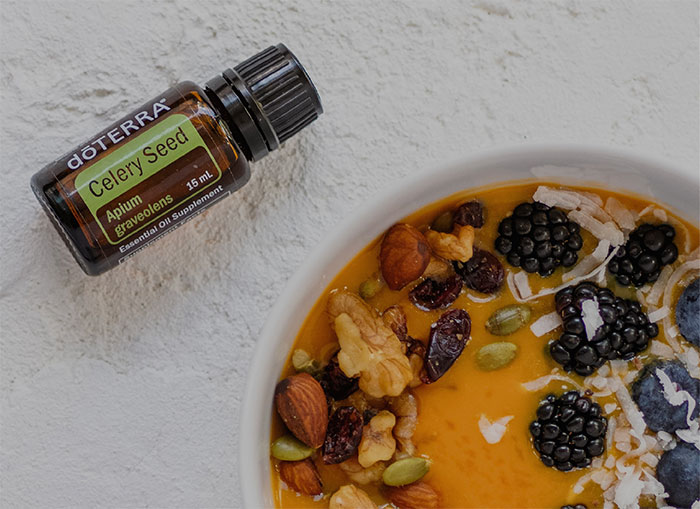 一碗莓果、堅果、燕麥片和一瓶芹菜籽精油。