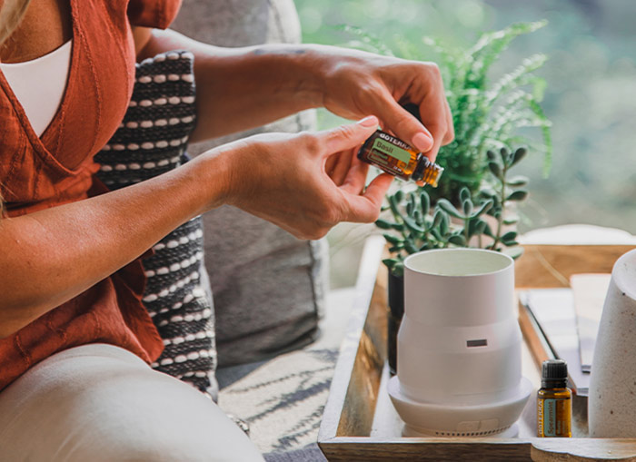 a woman diffusing basil essential oil