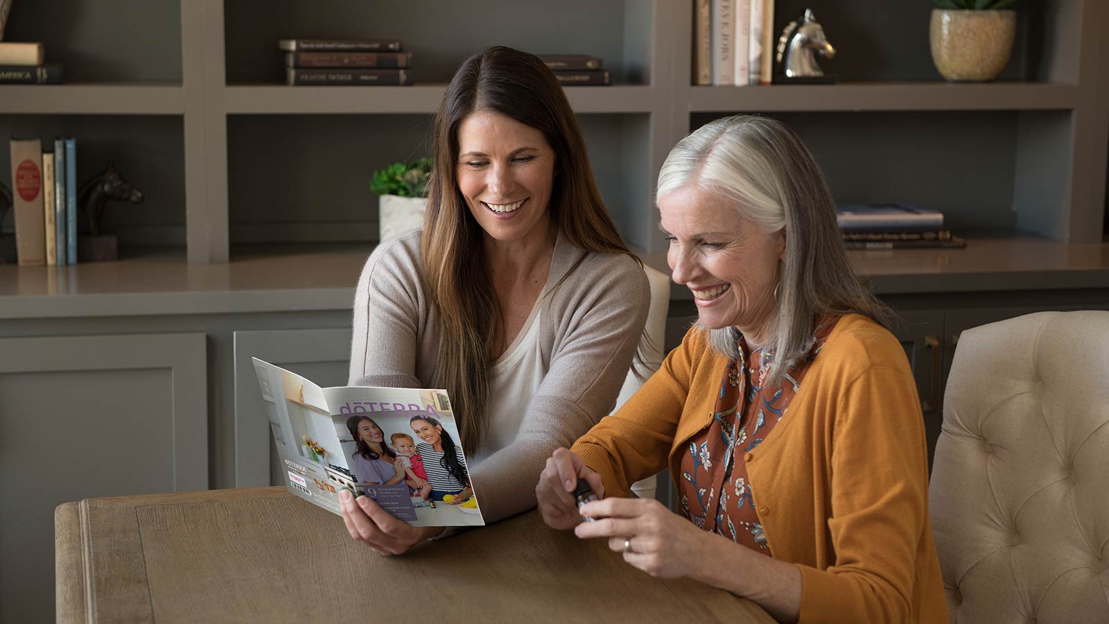 Two women reading the Welcome to doTERRA Booklet