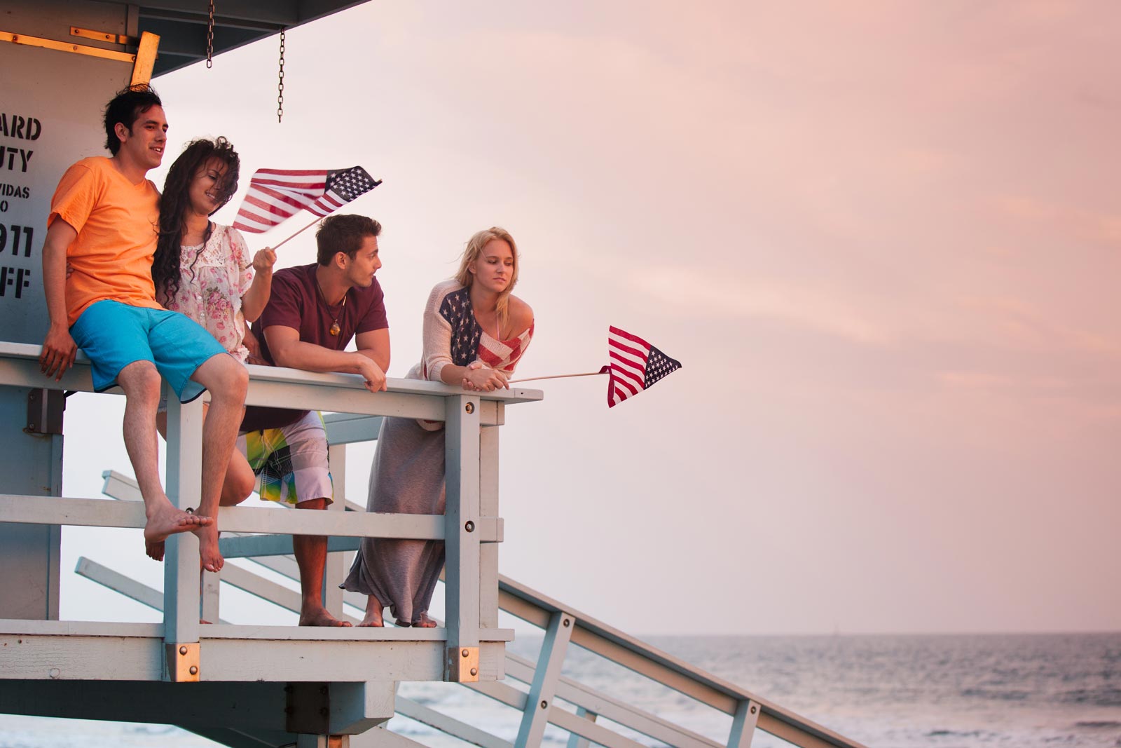 People waving American flags on a pier