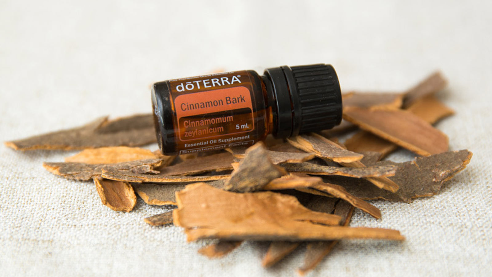 doTERRA Cinnamon Bark essential oil laying a pile of bark. 