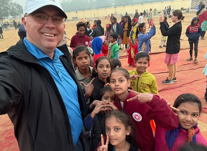 Dr. Russell Osgothorpe posing for a selfie with several children from the leprosy-affected community.