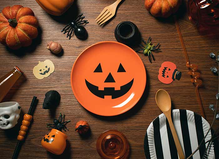 An array of Halloween themed decorations laying on a brown table. 