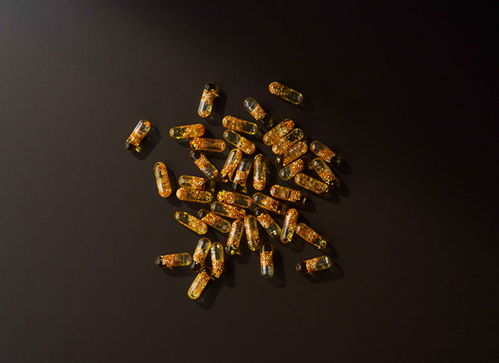 Frankincense Boswellic Acid Complex capsules scattered on a black background. 