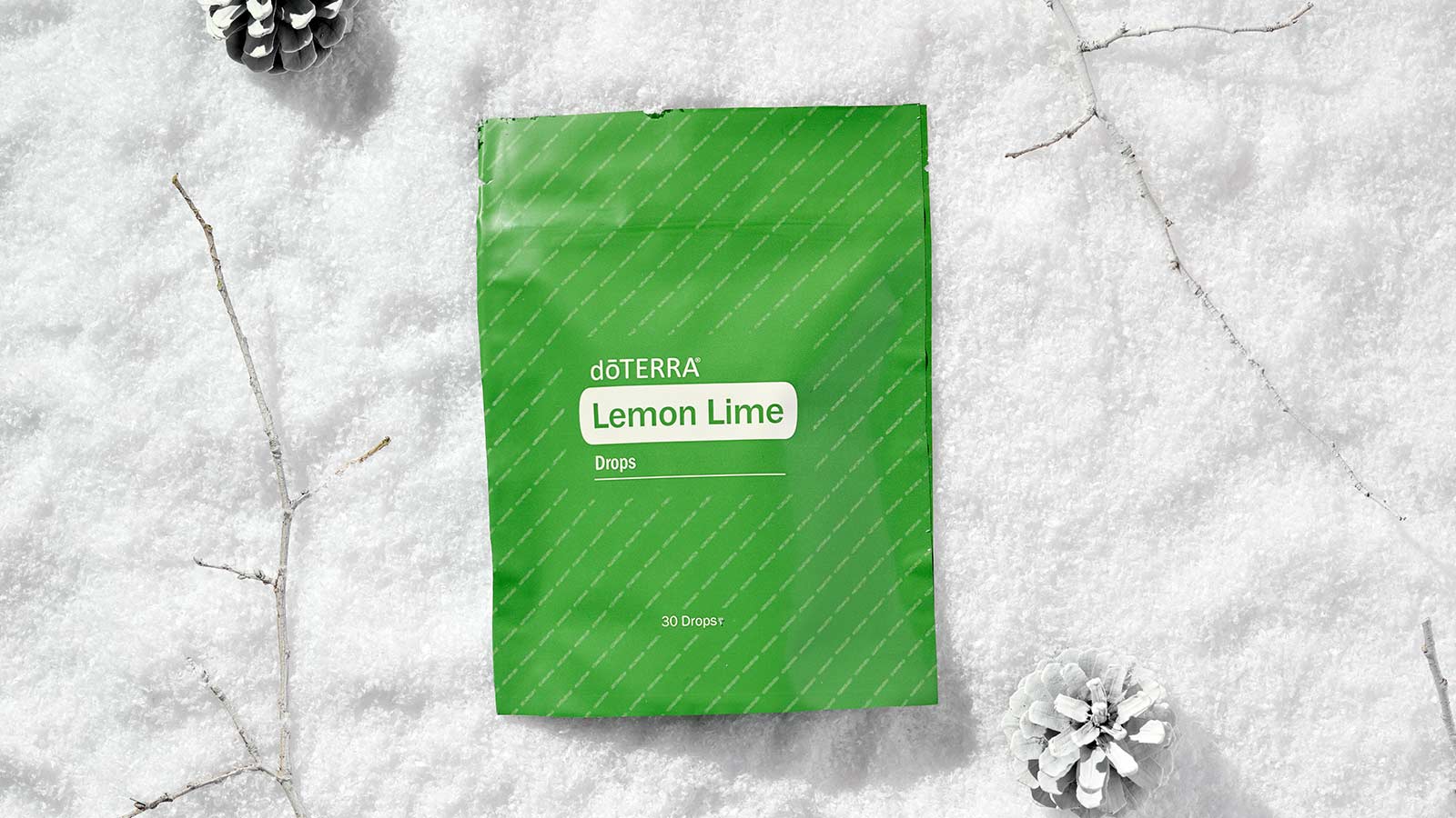 Lemon Lime Drops laying on a soft, snow-like surface surrounded by white twigs and pinecones. 