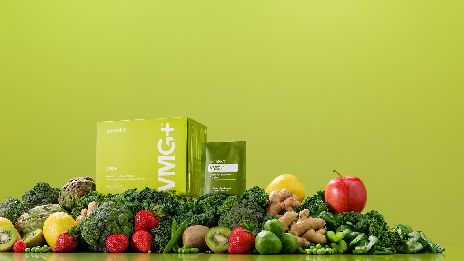 VMG+ box and sachet sitting on a pile of fruits and vegetables, encompassed by a lime-green background.