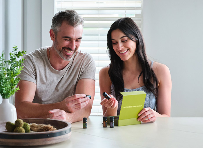 Two people sat at a table with various doTERRA products