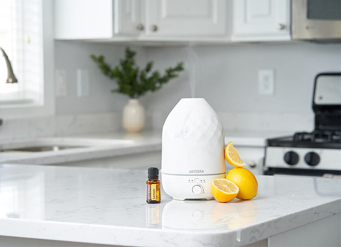 Lemon Essential Oil beside Volo Diffuser and some lemons