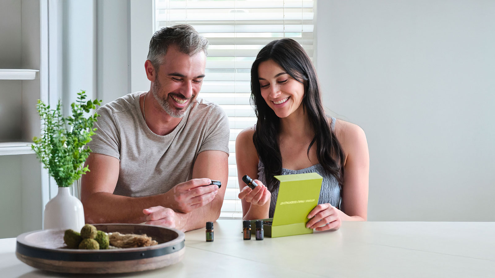Two people sat at a table with various doTERRA products