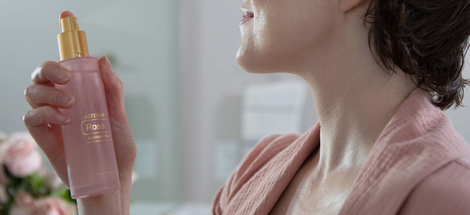 A woman spraying her face with Rose Hydrosol Mist