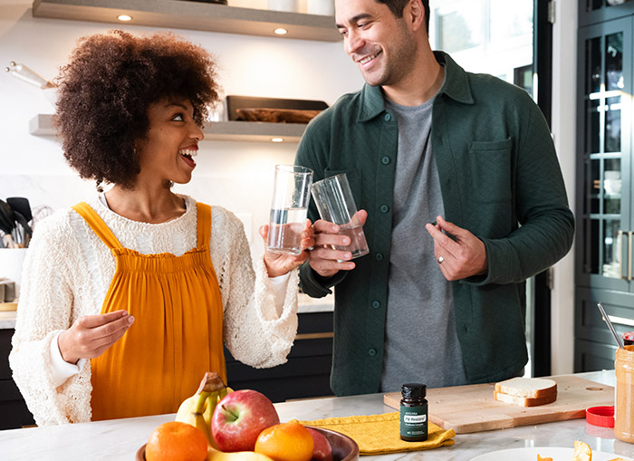 Two people talking and holding PB Restore