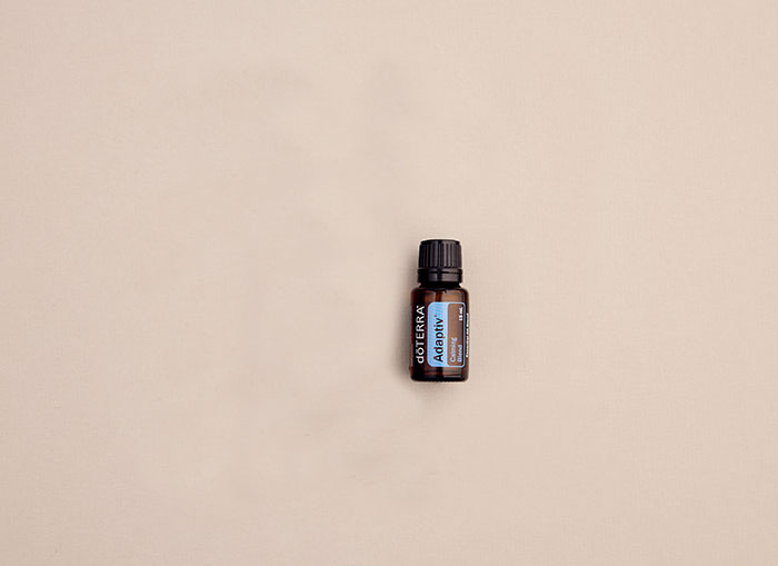 doTERRA Adaptiv essential oil bottle lying flat on plain background.   