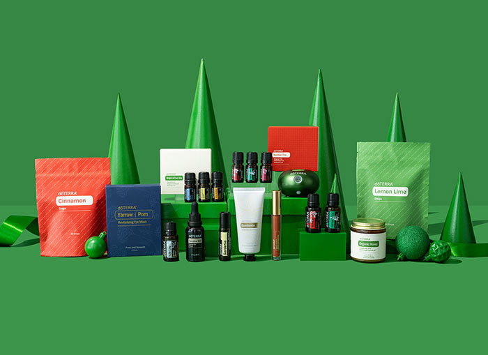 Each product of the doTERRA Holiday Collection, featured with a green background and pointed green trees.