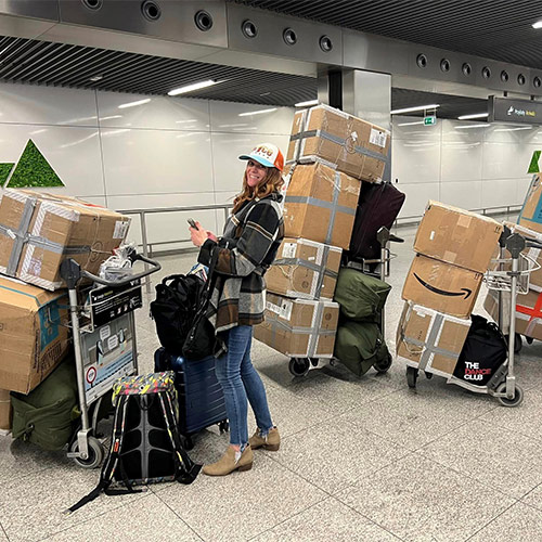 A woman with luggage and lot of boxes in an airport.