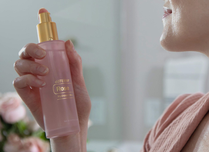 A woman spraying her face with Rose Hydrosol Mist