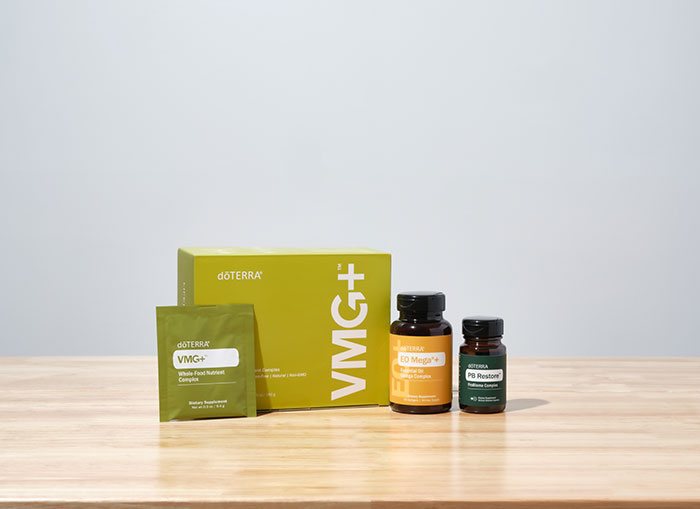 doTERRA VMG+, EO Mega+, and PB Restore sitting on a brown, wooden, countertop surface.