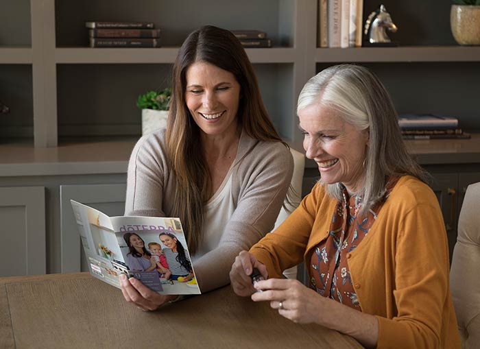 Two women reading the Welcome to doTERRA Booklet