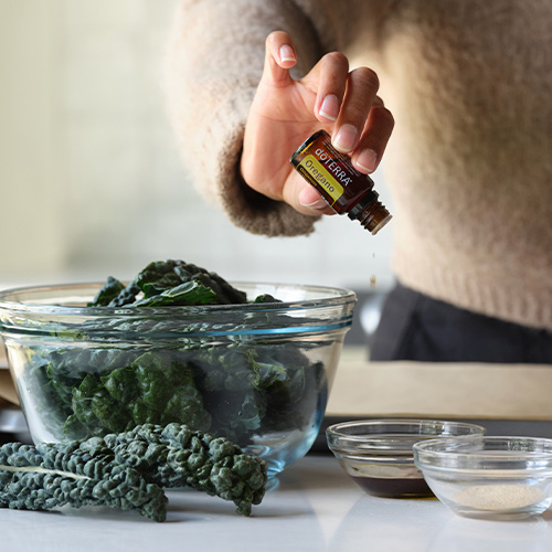 Woman cooking using doTERRA Oregano Essential Oil