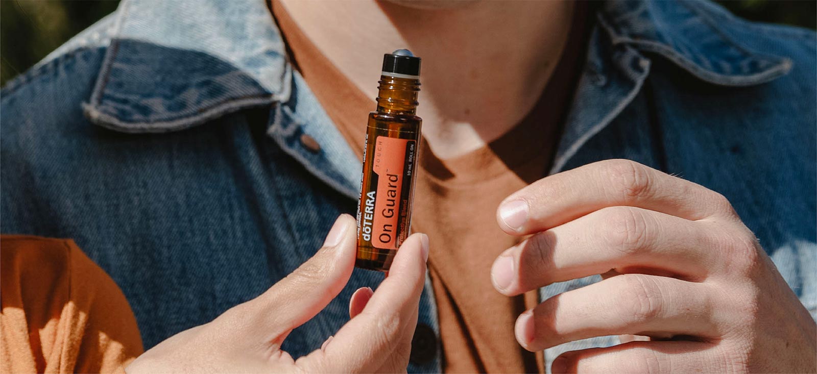 Person holding doTERRA On Guard Touch