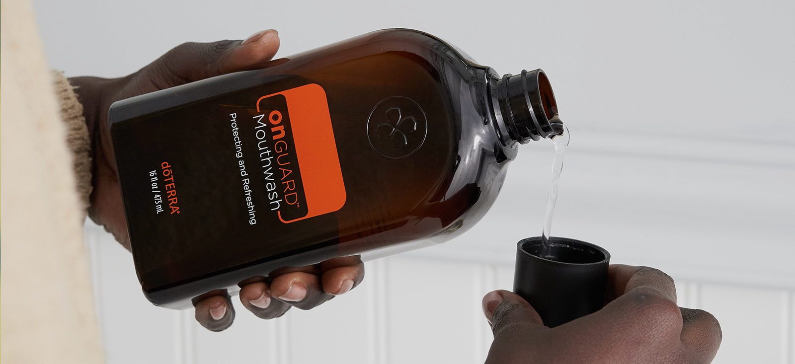 Man putting doTERRA Mouthwash in a cup