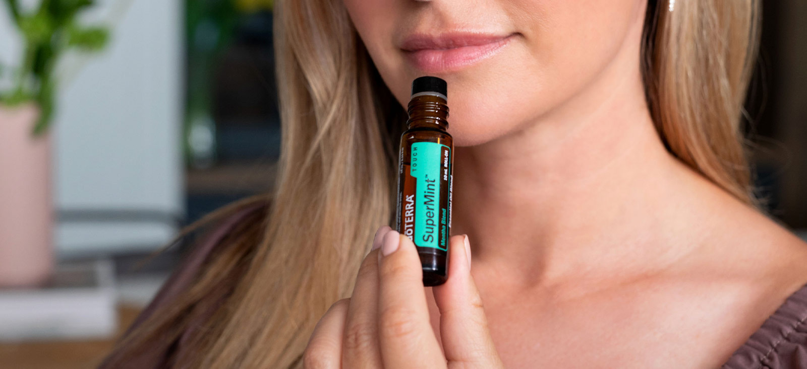 Woman holding SuperMint Touch Essential Oil